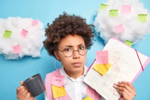 Lycéenne en difficulté scolaire tenant un cahier rempli d'équations mathématiques et de post-its de révision.