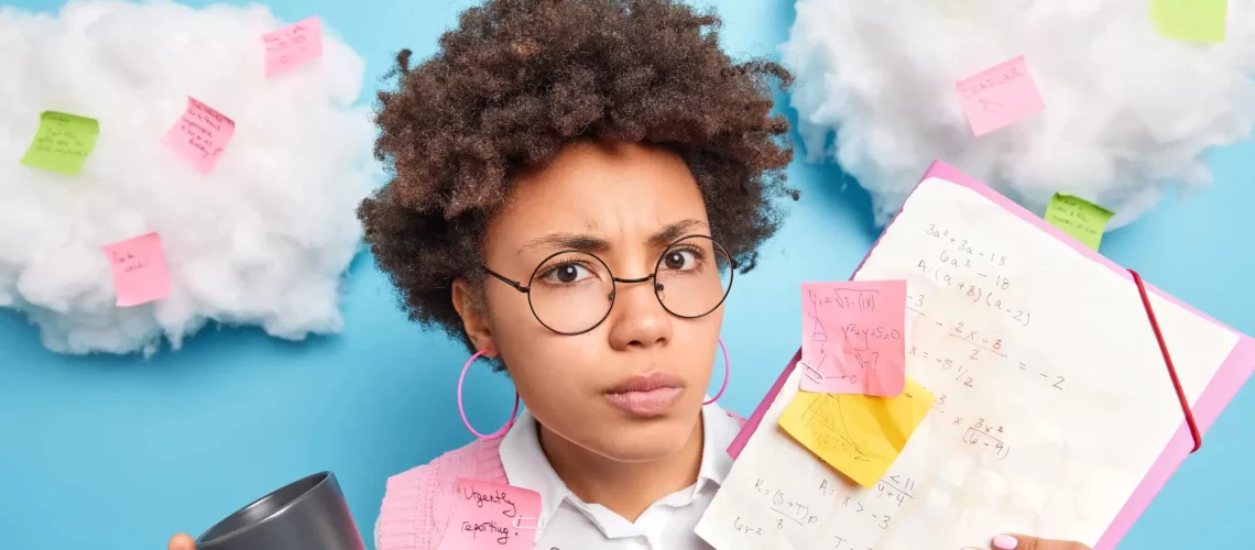 Lycéenne en difficulté scolaire tenant un cahier rempli d'équations mathématiques et de post-its de révision.